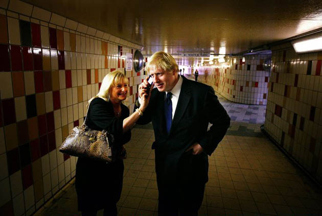 London Mayoral candidate Boris Johnson takes a phone call from a voter during a campaign walk through a subway in Gant's Hill