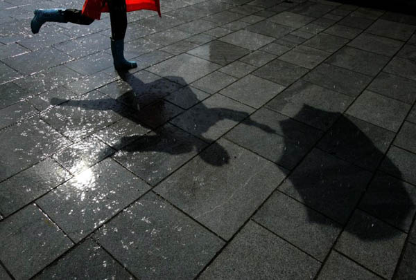 Glasgow, UK: A Gampta 'Singing in the Rain' dancer performs under a rain machine at Cowcaddens Station as part of Glasgow's first Subway festival