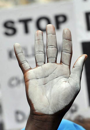 London, UK: Demonstrators display the white hand, symbol of peace in Darfur, as some 300 protesters gather at the Sudanese embassy