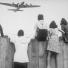 West Berlin children perched on the fence of Tempelhof airport watch the fleets of U.S. airplane