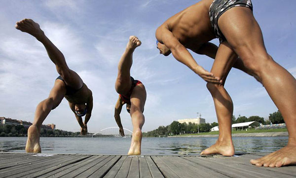 Seville, Spain: Swimmers dive into the Guadalquivir river during a training session of the World Open Water Swimming Championships