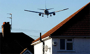 A plane bound for Heathrow flies over nearby houses