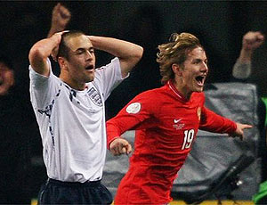 Russia's Roman Pavlyuchenko runs past a dejected Joe Cole after scoring the winner against England