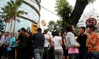 Staff and visitors stand outside an evacuated shopping centre in Medan, Indonesia, after an earthquake today