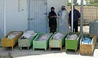 People gather at the Baquba hospital morgue next to caskets containing the bodies of six of their family members who were killed by a roadside bomb south of Baquba, Iraq