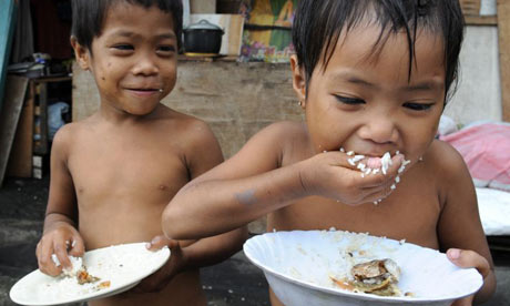 Filipino children eat rice, a staple crop that is under pressure across the developing world