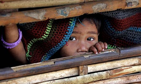 A Bhutanese refugee looks from a bamboo hut in the Ti Mai camp, Nepal