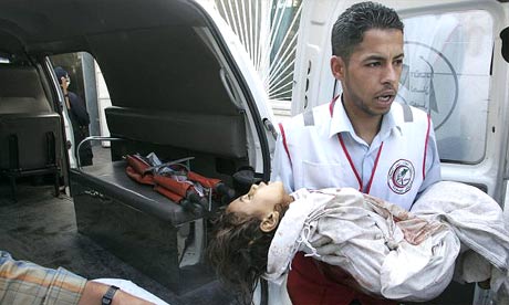A medic carries the body of a Palestinian child hit by an Israeli attack