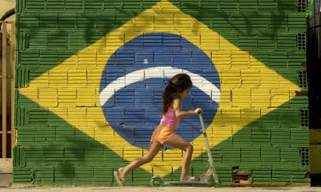 A young girl plays in front of a Brazilian flag in Rio de Janeiro