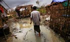 A Burmese man walks through his home in a village outside Rangoon
