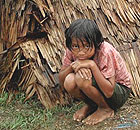 A Burmese child outside a makeshift home in Bogalay