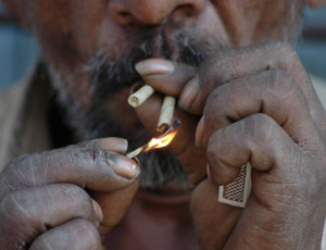 A worker lights a bidi, a small, cheaply made cigarette in Vadodara, India. Photograph: Ajit Solanki/AP
