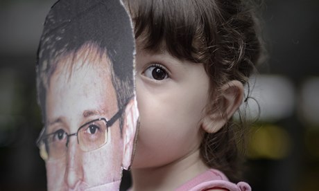 A child holds a cut out of Edward Snowden.