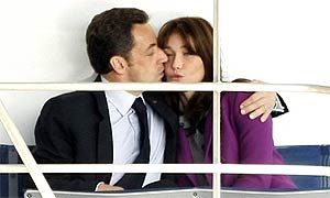 The French president, Nicolas Sarkozy, kisses his wife, Carla Bruni-Sarkozy, on a boat on the Thames